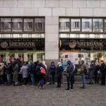 Russians line up at banks, prices may rise after sanctions